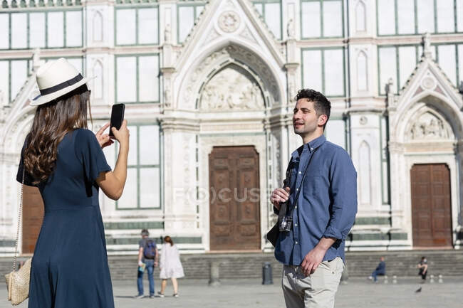 Feminino turista fotógrafo homem através de telefone inteligente na Piazza Di Santa Croce, Florença, Itália — Fotografia de Stock
