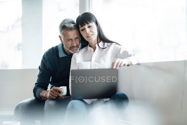 Business couple using laptop while working together in coffee shop — Stock Photo