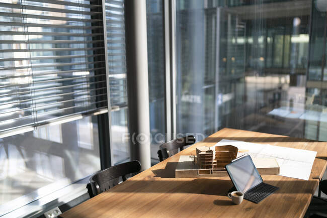 Modèle architectural avec plan et ordinateur portable sur la table au bureau — Photo de stock