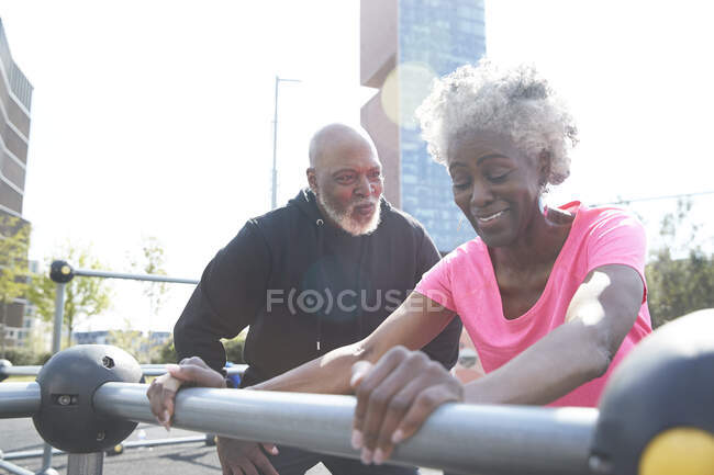 Hombre mirando a la mujer haciendo ejercicio en el parque - foto de stock