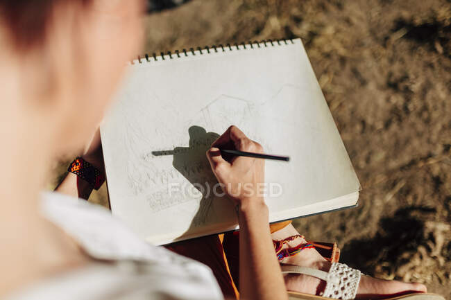 Giovane artista disegno in notebook a spirale — Foto stock