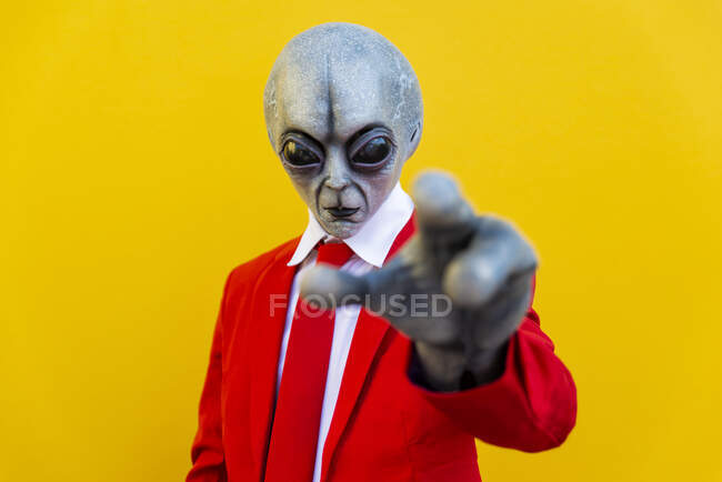 Portrait de l'homme portant un costume extraterrestre et costume rouge vif atteignant vers la caméra — Photo de stock