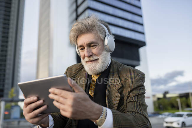 Бізнесмен дивиться відео на цифровій планшеті в місті. — стокове фото