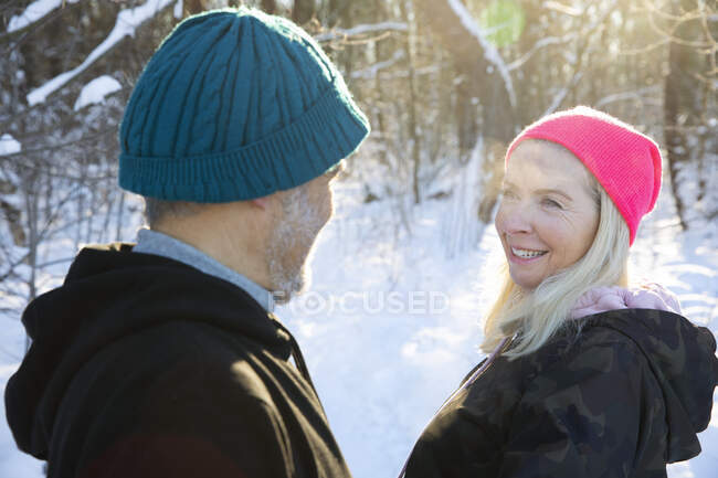 Donna anziana sorridente mentre guarda l'uomo durante l'inverno — Foto stock