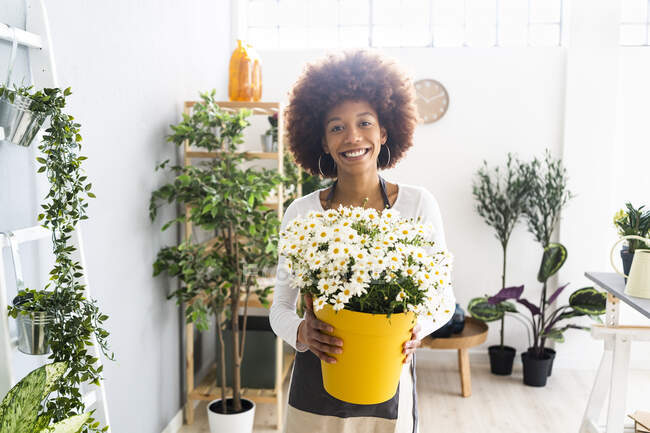 Усміхнена жінка-флорист тримає купу квітів в магазині — стокове фото