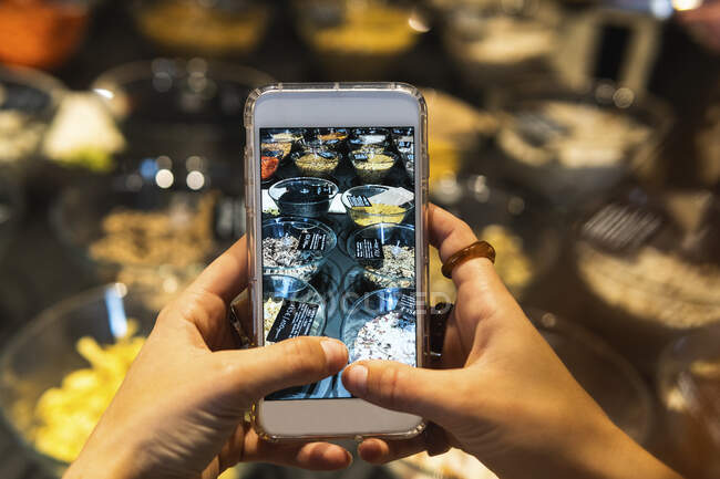 Junge Frau fotografiert Lebensmittel im Supermarkt — Stockfoto