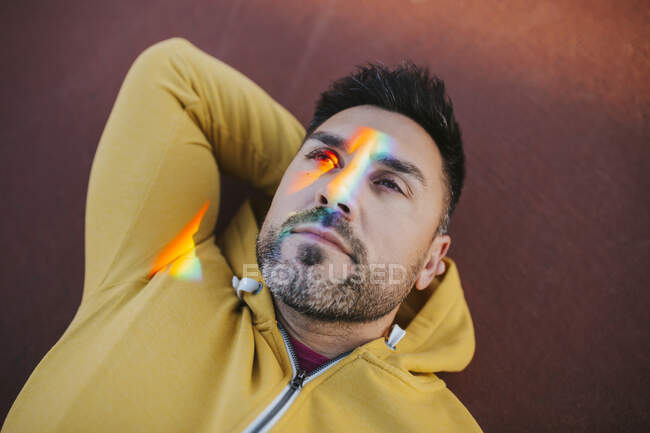Homme barbu avec spectre sur le visage tout en étant couché au sol — Photo de stock