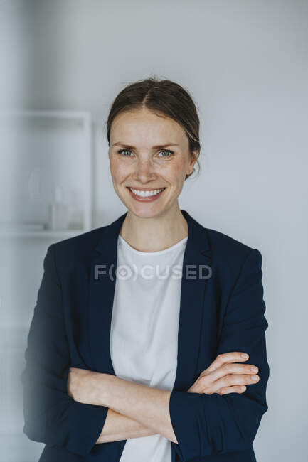 Femme d'affaires souriante avec bras croisés — Photo de stock