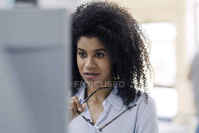 Деловая женщина с кудрявыми волосами, сконцентрированная во время работы в промышленности — стоковое фото