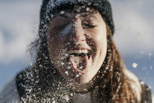 Metà donna adulta che sporge la lingua mentre gioca durante la nevicata — Foto stock