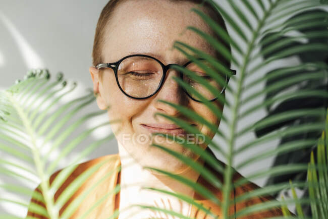 Sorridente donna d'affari piante odorose con gli occhi chiusi — Foto stock