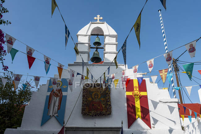 Grécia, Egeu do Sul, Horta, Várias bandeiras penduradas na frente da igreja de lavagem branca — Fotografia de Stock