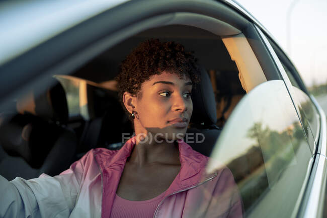 Молода жінка відвернулася від вікна, сидячи в машині. — стокове фото