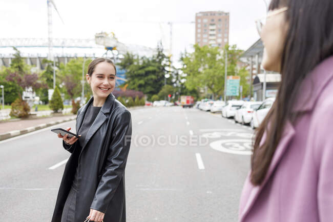 Colleghi sorridenti che si guardano mentre camminano per strada — Foto stock