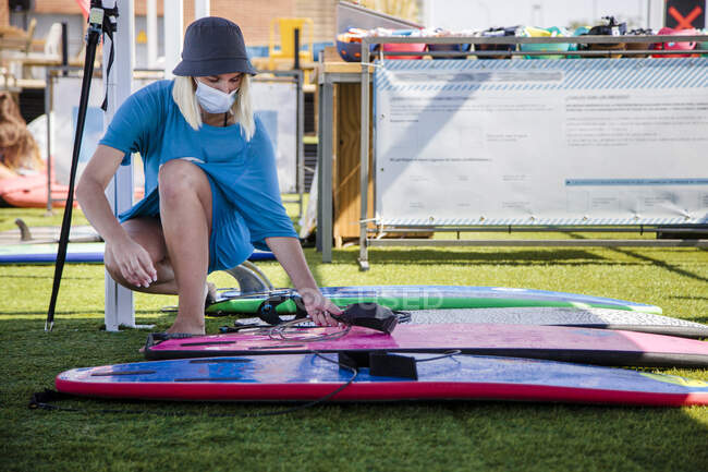 Молода жінка готує серфінг над травою під час пандемії. — стокове фото
