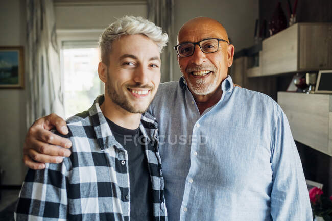Улыбающийся отец с сыном дома — стоковое фото