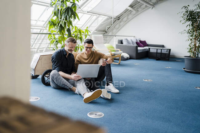 Equipe profissional masculina usando laptop enquanto está sentado no escritório criativo — Fotografia de Stock