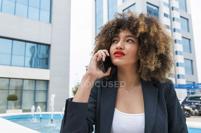 Belle Afro femme professionnelle parlant sur téléphone portable en ville — Photo de stock