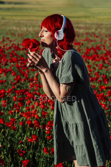 Mulher com olhos fechados cheirar flores em arquivado — Fotografia de Stock