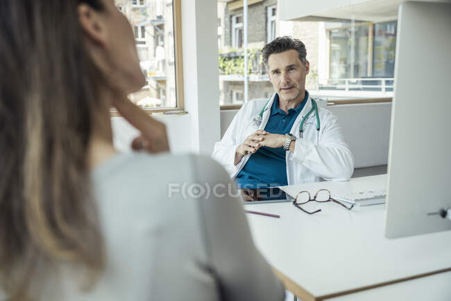 Médico masculino discutindo com paciente do sexo feminino no escritório — Fotografia de Stock