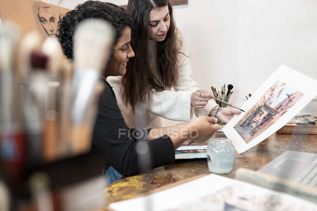 Giovani pittori di sesso femminile discutono di pittura in studio — Foto stock