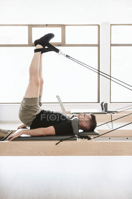 Male fitness instructor practicing pilates in studio — Stock Photo