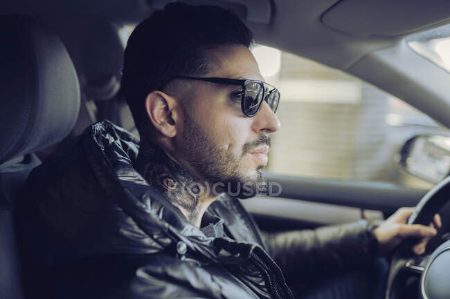 Hipster uomo guida auto mentre guardando altrove — Foto stock
