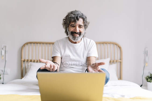 Uomo gesticolare durante la videochiamata sul computer portatile a casa — Foto stock
