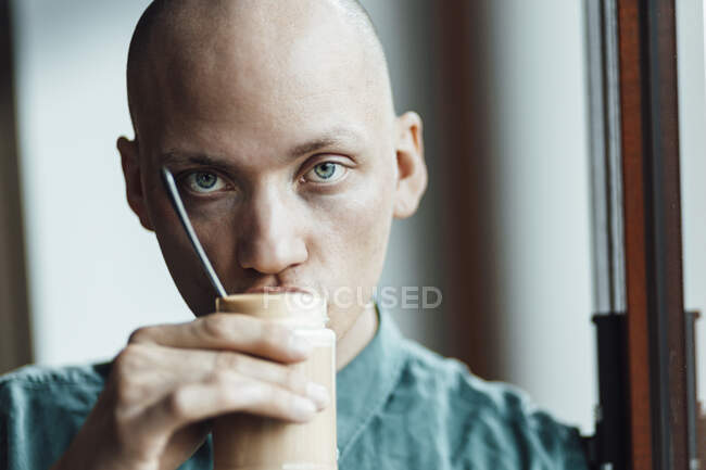 Dueño de café masculino mirando mientras bebe café - foto de stock