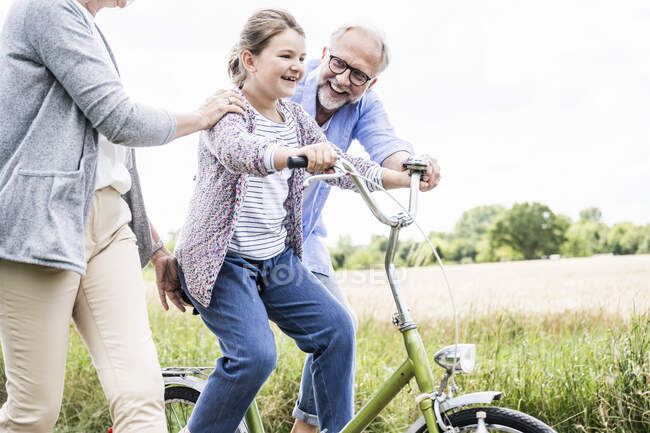 Enkelin übt mit Großeltern auf Wiese — Stockfoto