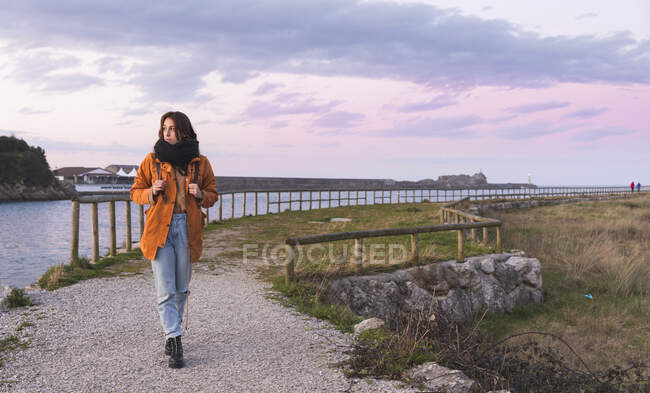 Spain, Cantabria, San Vicente de la Barquera, Young backpacker tourist enjoying sea coast at sunset — Stock Photo
