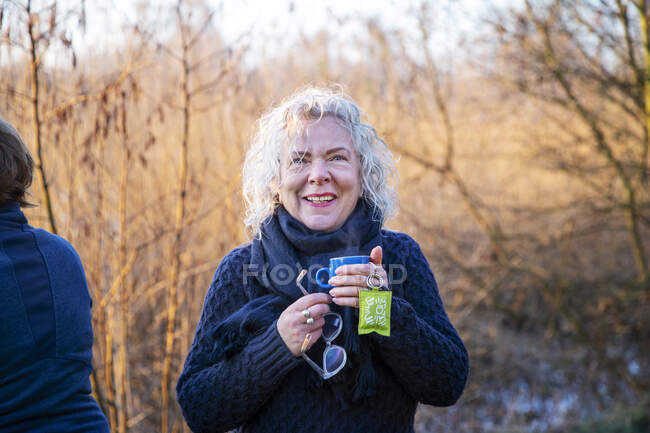 Smiling senior woman having coffee at morning — Stock Photo
