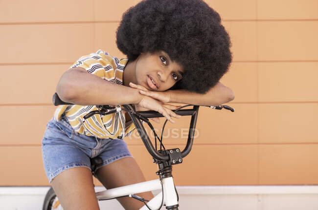 Afro femme appuyé sur le guidon de vélo — Photo de stock