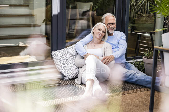 Femme souriante assise avec l'homme au balcon — Photo de stock