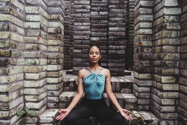 Young female dancer meditating in lotus position with eyes closed — Stock Photo