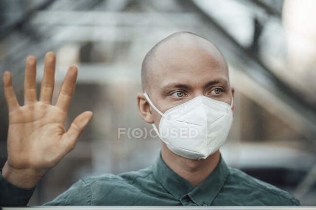 Empresario con máscara protectora detrás de la ventana de la cafetería - foto de stock