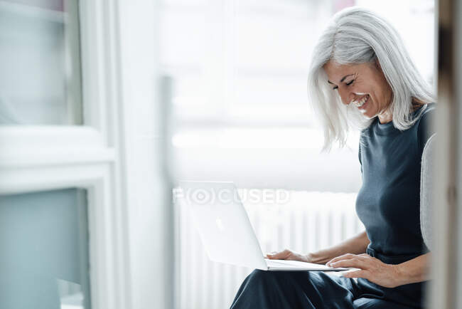 Felice donna d'affari video chiamata attraverso il computer portatile in ufficio — Foto stock