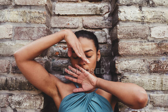 Female dancer with eyes closed practicing in front of stone wall — Stock Photo