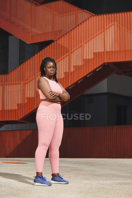 Confident curvy woman standing with arms crossed on footpath — Stock Photo