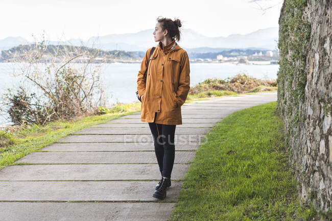 Giovane donna che cammina da sola lungo il lungomare del Golfo di Biscaglia — Foto stock