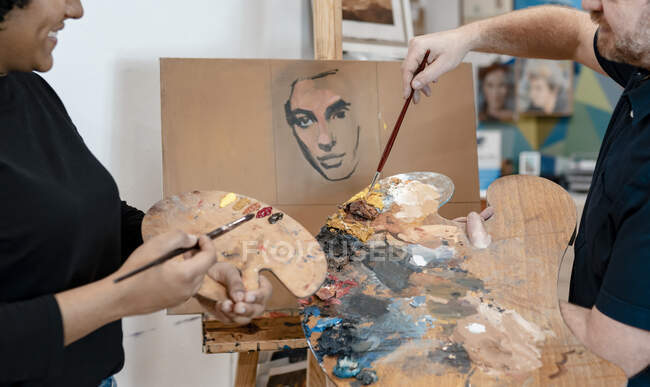 Художник-мужчина преподает живопись художнице — стоковое фото