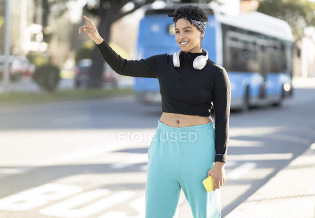 Funky woman hailing ride on roadside in city — Stock Photo