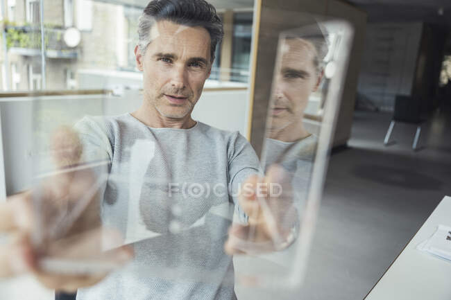 Businessman checking glass model in office — Stock Photo
