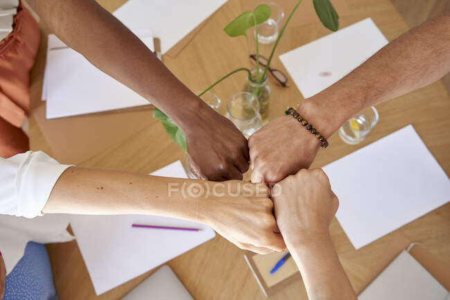 Male and female coworkers giving fist bumps at workplace — Stock Photo