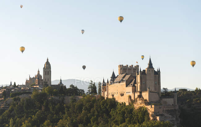 España, Castilla y León, Segovia, Globos de aire caliente volando Catedral de Segovia y Alcázar de Segovia - foto de stock