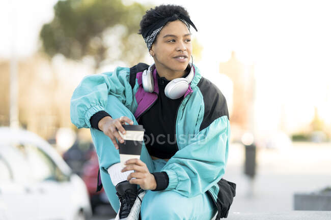 Woman holding reusable cup while looking away in city — Stock Photo