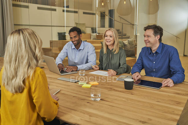 Smiling professional colleagues discussing working in board room — Stock Photo