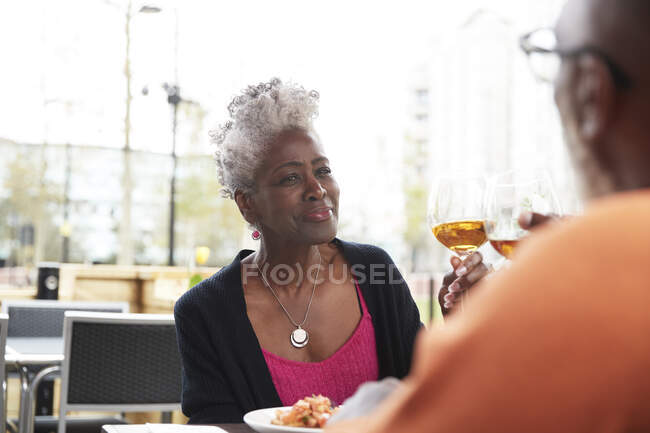 Улыбающаяся женщина тост с мужчиной в ресторане — стоковое фото