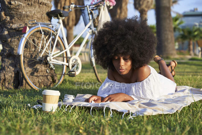 Afro-Frau mit geschlossenen Augen entspannt auf Picknickdecke — Stockfoto