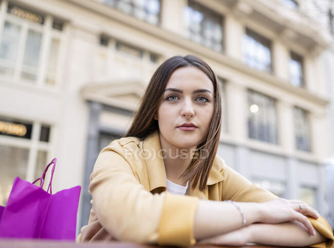 Giovane donna con borse della spesa di fronte all'edificio — Foto stock